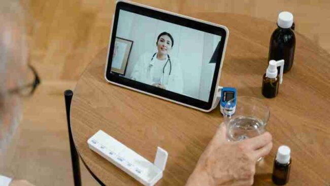 Senior adult having a virtual doctor consultation on a tablet with medications on the table., tags: deutschland digitale - pexel